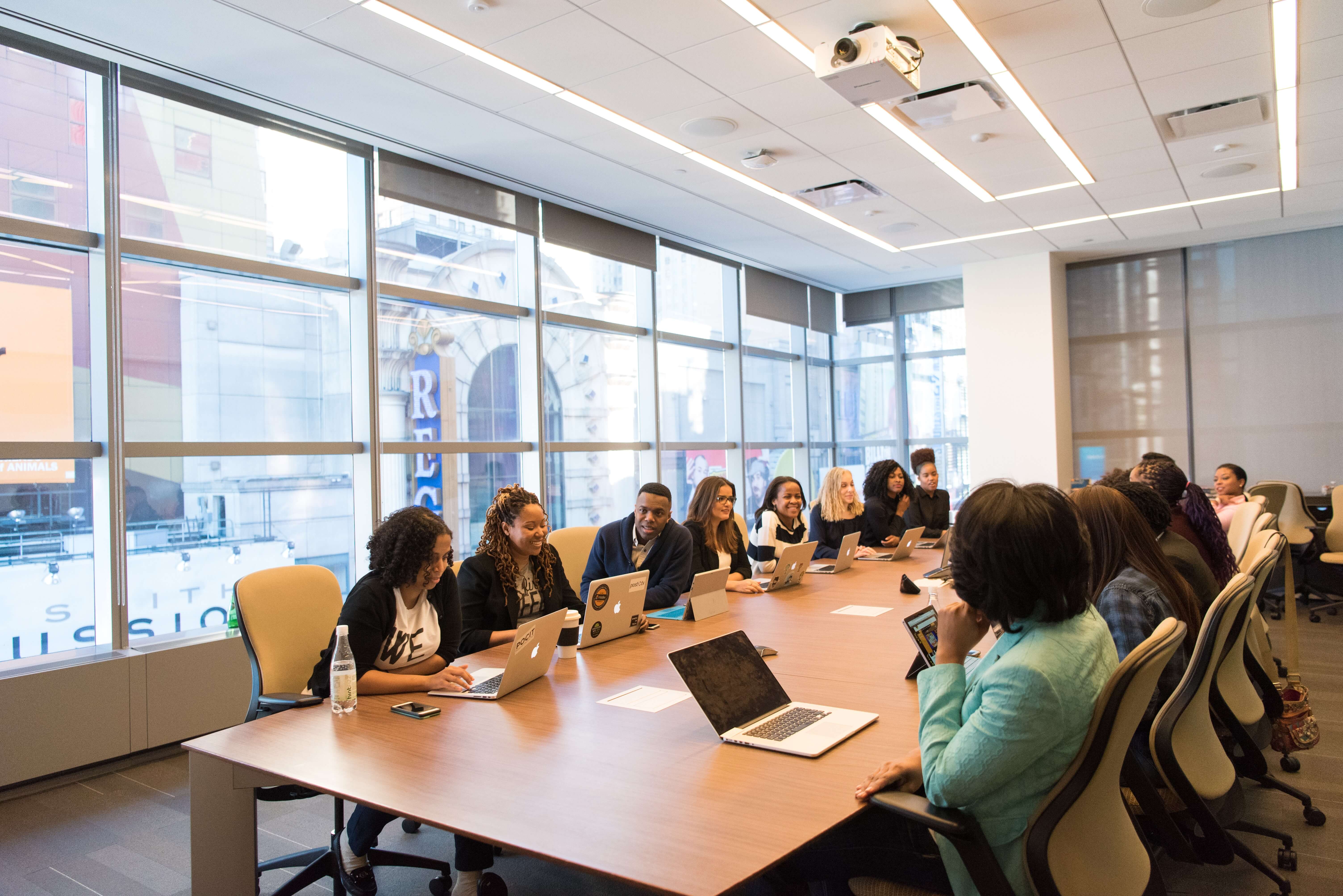 Employees in conference room on laptops